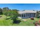 Aerial view of the rear of the home featuring a sunroom and lush backyard landscaping at 15856 Cobble Mill Dr, Wimauma, FL 33598