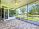 Screened porch with brick floor overlooking pond and lush landscaping at 15856 Cobble Mill Dr, Wimauma, FL 33598