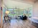 Bright sunroom with floor-to-ceiling windows offering scenic views of the lake at 15856 Cobble Mill Dr, Wimauma, FL 33598