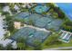 Aerial view showcases the many tennis courts with beautiful landscaping surrounding in this community at 15856 Cobble Mill Dr, Wimauma, FL 33598