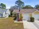 Charming home showcasing well-maintained landscaping, a two-car garage and a welcoming front lawn at 4210 Revere Cir, New Port Richey, FL 34653