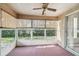 Bright sunroom with large windows, bamboo blinds, and a ceiling fan for year-round comfort at 4210 Revere Cir, New Port Richey, FL 34653