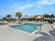 Beautiful community pool with ample lounge chairs, palm trees, and a convenient entry point with handrails at 8463 Canyon Creek Trl, Parrish, FL 34219