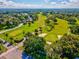 Beautiful aerial view of Dunedin Golf Course and sand traps surrounded by lush trees at 1214 Royal Oak Dr, Dunedin, FL 34698