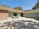 Exterior of home with two chairs on the front porch with a two-car garage and a brick exterior at 1214 Royal Oak Dr, Dunedin, FL 34698