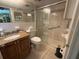 Well-lit bathroom featuring tiled shower with glass door and granite vanity at 2060 Marilyn St # 133, Clearwater, FL 33765