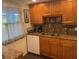 Well-lit kitchen featuring wood cabinets, granite countertops, and a dishwasher at 2060 Marilyn St # 133, Clearwater, FL 33765