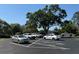 Well-maintained parking area with multiple vehicles under the shade of mature trees and a clear blue sky at 2060 Marilyn St # 133, Clearwater, FL 33765