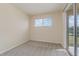 Bedroom with neutral colored walls, carpet, and a sliding glass door at 207 Winding River Trl, Bradenton, FL 34212