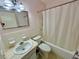 Bathroom featuring a shower/tub combo, sink, toilet, and updated lighting at 2311 Brisbane St # 65, Clearwater, FL 33763