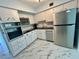 Kitchen with white cabinets, stainless steel appliances, and marble floors at 2311 Brisbane St # 65, Clearwater, FL 33763