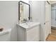 Bathroom features updated vanity with stylish mirror, white fixtures, and convenient storage at 2335 Heron Cir, Clearwater, FL 33762