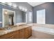 Bathroom offering double sinks with granite countertops, a bathtub, and tile flooring at 2419 Victoria Gardens Ln, Tampa, FL 33609