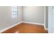 Neutral bedroom features hardwood flooring and a large window with natural light at 2419 Victoria Gardens Ln, Tampa, FL 33609
