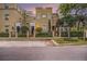 Charming multi-story townhomes featuring secure gates and beautiful greenery along the sidewalk and street at 2419 Victoria Gardens Ln, Tampa, FL 33609