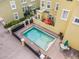 Aerial view of a pristine community pool with brick patio, surrounded by lush landscaping and comfortable seating at 2419 Victoria Gardens Ln, Tampa, FL 33609