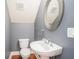Charming half bathroom with pedestal sink, oval mirror, and gray and white color scheme at 2419 Victoria Gardens Ln, Tampa, FL 33609