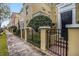 Charming street view of townhomes, each with unique architectural details and wrought iron fences at 2419 Victoria Gardens Ln, Tampa, FL 33609