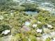 Aerial view of the community pool, tennis courts, and lake surrounded by trees at 2730 5Th Ct, Palm Harbor, FL 34684