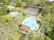 Aerial view of community pool, tennis courts, playground, and surrounding greenery at 2730 5Th Ct, Palm Harbor, FL 34684
