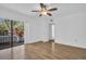 Bright bedroom features wood floors, ceiling fan, and sliding doors leading to a balcony at 2730 5Th Ct, Palm Harbor, FL 34684