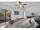 Comfortable bedroom features wood floors, ceiling fan, and sliding doors that lead to a balcony at 2730 5Th Ct, Palm Harbor, FL 34684