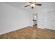 An empty bedroom with hardwood floors, a ceiling fan, closet, and ensuite bathroom at 2730 5Th Ct, Palm Harbor, FL 34684