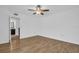 An empty bedroom with hardwood floors, a ceiling fan, and an ensuite bathroom at 2730 5Th Ct, Palm Harbor, FL 34684