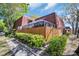 Inviting exterior view of a brick home with a screened patio and well-maintained landscaping surrounded by mature trees at 2730 5Th Ct, Palm Harbor, FL 34684