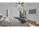 A stylish main bedroom with hardwood floors, balcony access, and an ensuite bathroom at 2730 5Th Ct, Palm Harbor, FL 34684