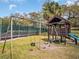 Community playground with swings, a slide, and a covered fort on a grassy lawn at 2730 5Th Ct, Palm Harbor, FL 34684