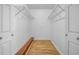 Spacious walk-in closet featuring wood floors, metal shelves, and white walls at 2730 5Th Ct, Palm Harbor, FL 34684