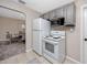 Efficient kitchen featuring white appliances and light gray cabinets, adjacent to a dining area at 6923 Dartmouth N Ave, St Petersburg, FL 33710