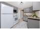 Bright kitchen featuring gray cabinets, granite countertops, stainless steel appliances, and tiled flooring at 6923 Dartmouth N Ave, St Petersburg, FL 33710