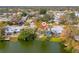This aerial view shows a charming home in a lakeside neighborhood surrounded by mature trees and lush greenery at 8501 47Th N St, Pinellas Park, FL 33781