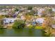 This aerial view shows a charming home in a lakeside neighborhood surrounded by mature trees and lush greenery at 8501 47Th N St, Pinellas Park, FL 33781