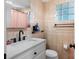 Neutral-toned bathroom with glass block window, white vanity, toilet and shower with curtain at 8501 47Th N St, Pinellas Park, FL 33781