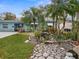 Landscaped front yard with a stone path leading to a beautiful waterfall feature at 8501 47Th N St, Pinellas Park, FL 33781