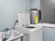 A well-lit laundry room features a washing machine, utility sink, and hot water heater at 8501 47Th N St, Pinellas Park, FL 33781