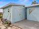 Image shows a cute, light blue backyard shed with barn doors and concrete flooring at 8501 47Th N St, Pinellas Park, FL 33781