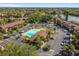 Panoramic aerial view of a community featuring a pool, parking, landscaping, and residential buildings near a lake at 880 S Village Lake N Dr # 106, St Petersburg, FL 33716