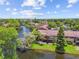Aerial view of the condominium complex with a beautiful pond, fountain, and mature trees in a park-like setting at 880 S Village Lake N Dr # 106, St Petersburg, FL 33716