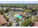 Expansive aerial view of a community with a pool, clubhouse, abundant parking, and beautiful landscaping near a lake at 880 S Village Lake N Dr # 106, St Petersburg, FL 33716