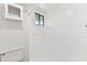 This bathroom features a white tiled shower, toilet, window, and mirrored medicine cabinet at 880 S Village Lake N Dr # 106, St Petersburg, FL 33716
