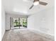 Spacious carpeted bedroom featuring sliding glass doors with a lovely view of the water and a ceiling fan at 880 S Village Lake N Dr # 106, St Petersburg, FL 33716