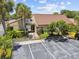 Exterior view of a clubhouse with a parking lot and lush landscaping, offering community amenities and a welcoming entrance at 880 S Village Lake N Dr # 106, St Petersburg, FL 33716