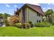 A view of the building featuring a well-manicured lawn and thoughtfully landscaped greenery at 880 S Village Lake N Dr # 106, St Petersburg, FL 33716