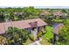 Exterior view of condo building with a brown roof, nice landscaping and a lake in the background in sunny Clearwater, Florida at 880 S Village Lake N Dr # 106, St Petersburg, FL 33716