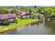 Exterior aerial view of condo with a lush green lawn, mature landscaping and a lovely pond view in sunny Clearwater, Florida at 880 S Village Lake N Dr # 106, St Petersburg, FL 33716