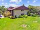 Exterior view of condo building with a brown roof, well manicured landscaping and a green lawn in Clearwater, Florida at 880 S Village Lake N Dr # 106, St Petersburg, FL 33716